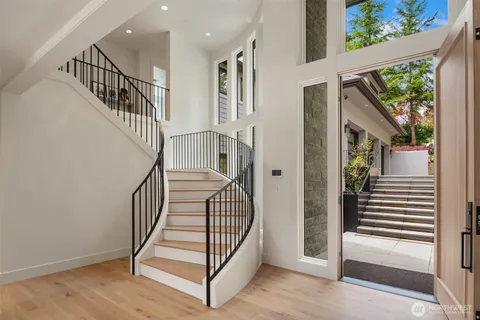 a view of a hallway with wooden floor and windows