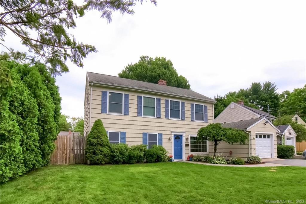 a front view of a house with a yard and trees