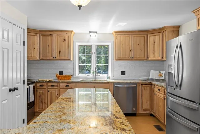 a kitchen with stainless steel appliances granite countertop a refrigerator sink and cabinets