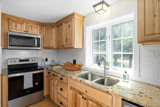 a kitchen with granite countertop a sink a stove and microwave