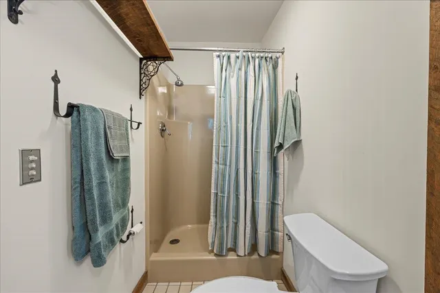 a bathroom with a toilet and a shower
