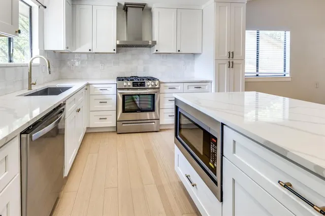 a kitchen with granite countertop white cabinets and white appliances