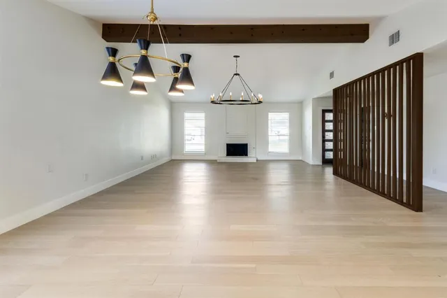 a view of a room with wooden floor ceiling fan and window