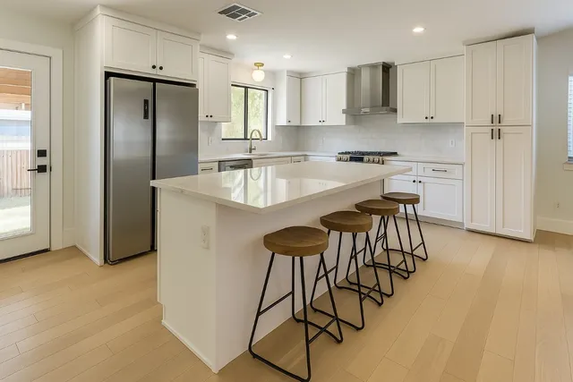a kitchen with stainless steel appliances granite countertop a stove a sink and a refrigerator
