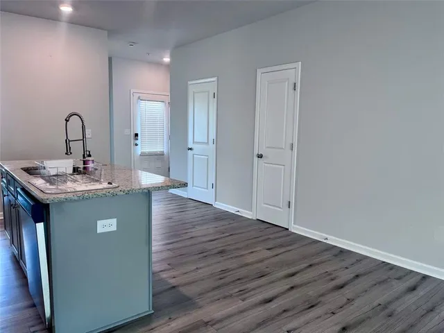 a room with kitchen island a sink wooden floor and view living room