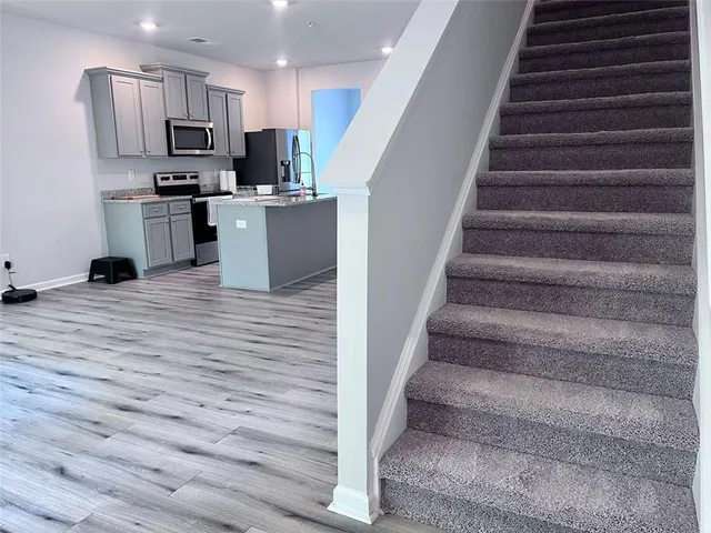 a view of kitchen with wooden floor and electronic appliances