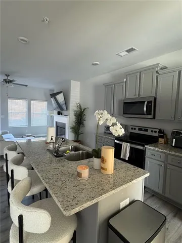 a kitchen with stainless steel appliances granite countertop a sink dishwasher a stove a refrigerator with a dining table and chairs