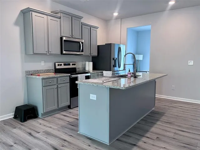 a kitchen with a sink a microwave a refrigerator and cabinets