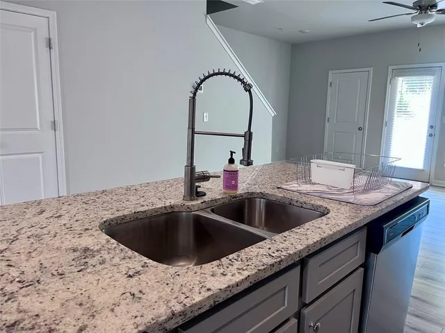 a kitchen with a sink and a wooden floor