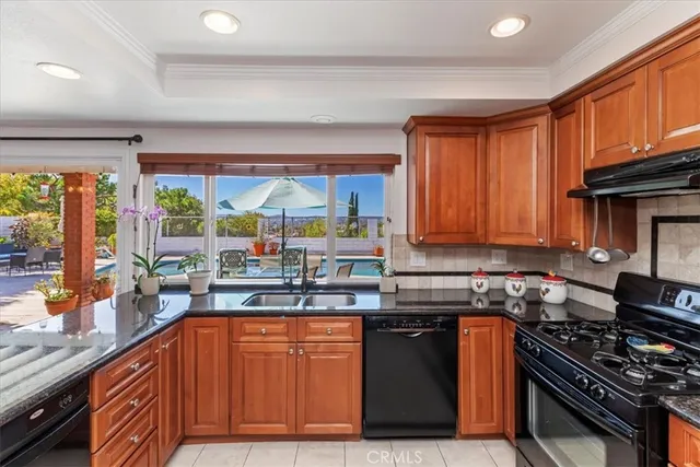 a kitchen with stainless steel appliances granite countertop a stove a sink dishwasher and cabinets with wooden floor