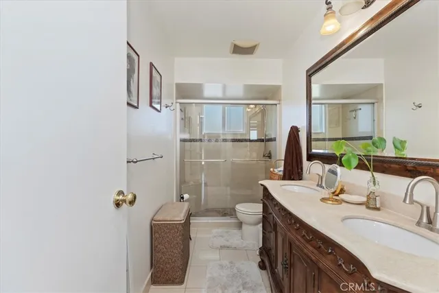 a bathroom with a double vanity sink toilet and shower