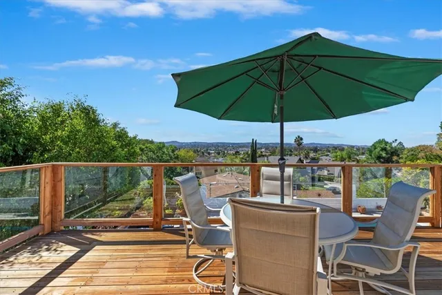 a view of a balcony with chairs and umbrella