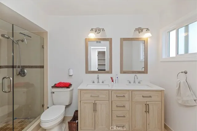 a bathroom with a sink toilet vanity and shower