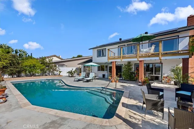 a front view of a house with swimming pool and sitting area