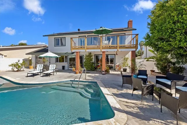 a view of a house with swimming pool and sitting area