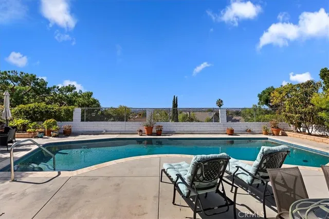 a view of a swimming pool and lounge chairs