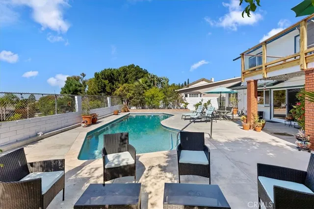 a view of a patio with couches table and chairs with wooden floor and fence