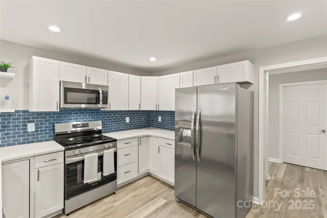 a kitchen with a refrigerator a microwave a stove and cabinets