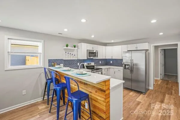 a kitchen with a refrigerator a stove a sink and a refrigerator with wooden floor