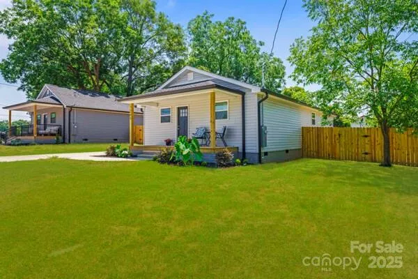a view of a backyard with plants and large trees