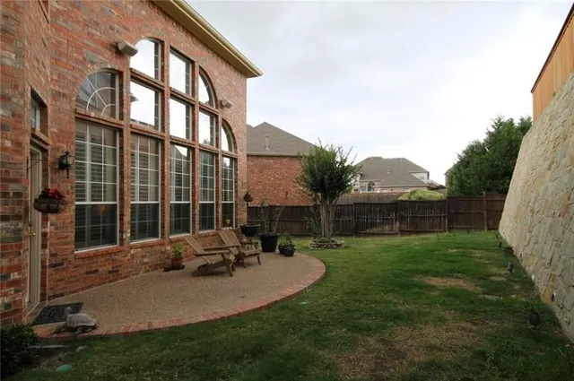 a view of a chair and table in backyard of the house