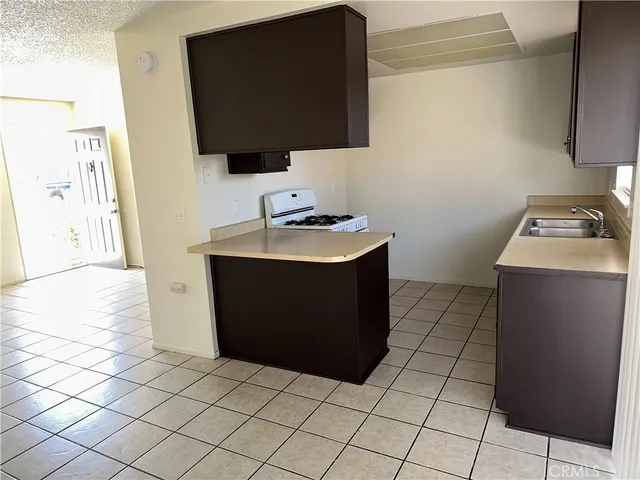 a kitchen with a sink a stove top oven and cabinets