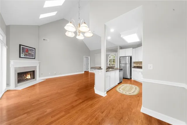a view of a kitchen with a sink a kitchen island cabinetry and chandelier