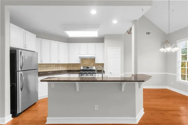 a kitchen with kitchen island a sink stainless steel appliances and window