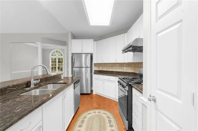 a kitchen with stainless steel appliances granite countertop a sink stove and refrigerator