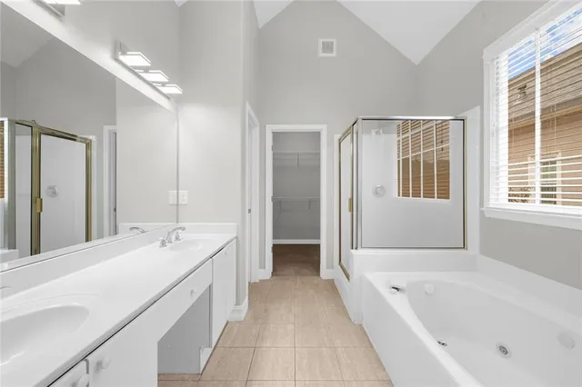 a spacious bathroom with a tub sink shower and a mirror