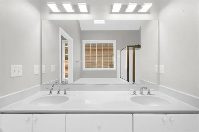 a bathroom with double vanity sinks and a mirror