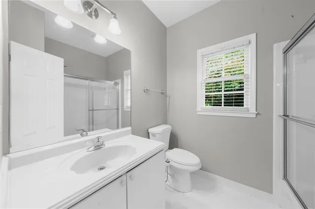 a bathroom with a toilet sink a mirror and a window