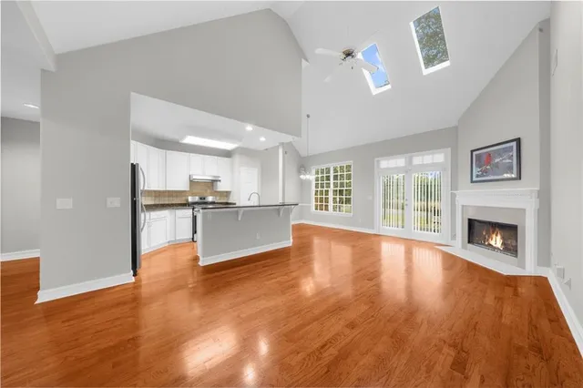 a view of kitchen and hall with wooden floor and a fireplace