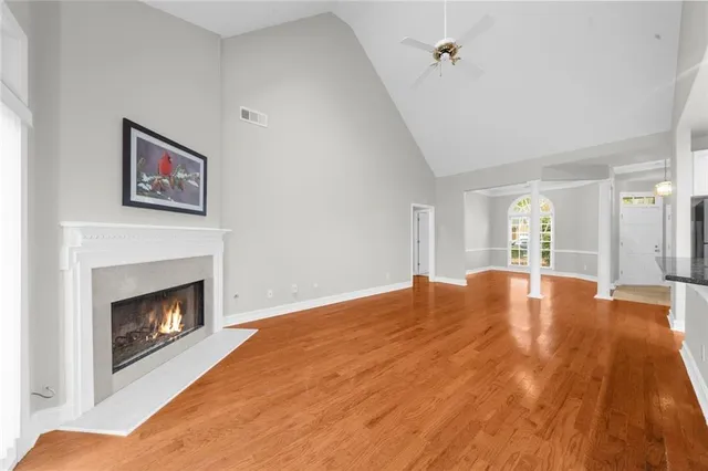 a view of empty room with wooden floor and fireplace