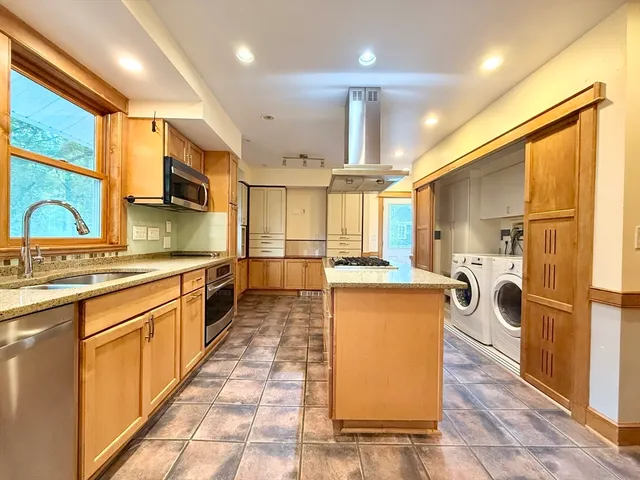 a kitchen with stainless steel appliances granite countertop a sink a stove and a refrigerator