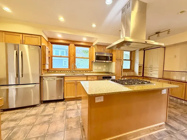 a kitchen with stainless steel appliances granite countertop a sink and a refrigerator