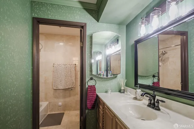 a bathroom with a granite countertop sink a mirror and a shower