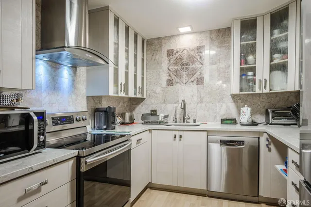 a kitchen with stainless steel appliances granite countertop a sink stove and cabinets