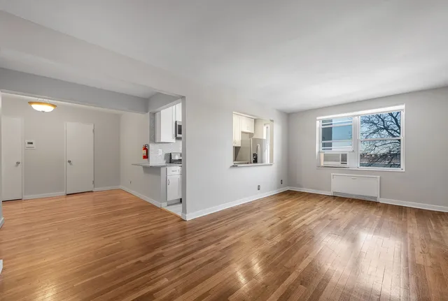 a view of empty room with wooden floor and window