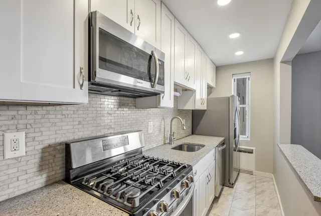 a kitchen with stainless steel appliances granite countertop a stove a refrigerator and a microwave