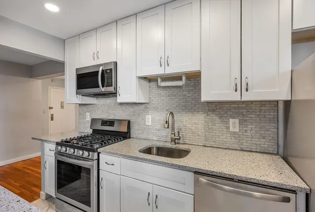 a kitchen with appliances a sink and cabinets