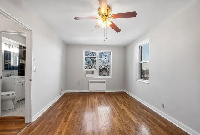 a view of room with window ceiling fan and wooden floor