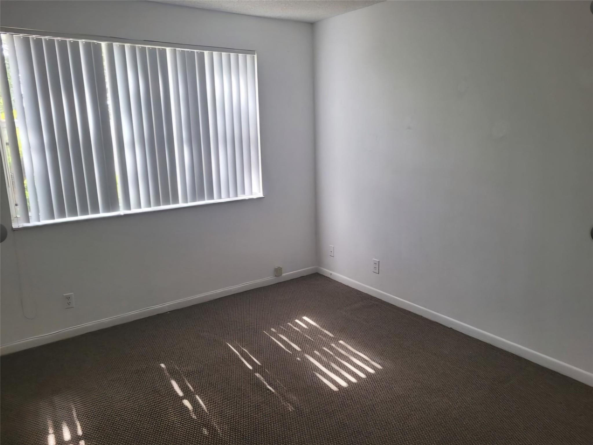 8741 Wiles Road, Unit 305 Coral Springs, FL 33067 - Photo 7 of 20 an empty room with a window