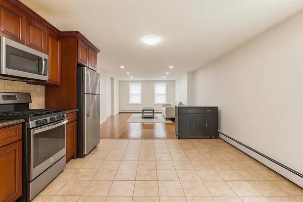 a large kitchen with stainless steel appliances granite countertop a stove a sink and a microwave