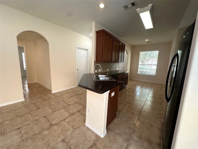a kitchen with stainless steel appliances granite countertop a refrigerator stove top oven and sink