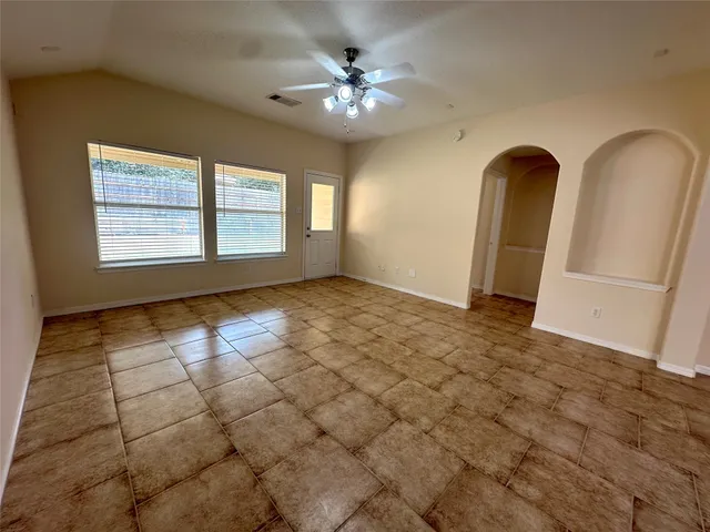 an empty room with large windows and fireplace