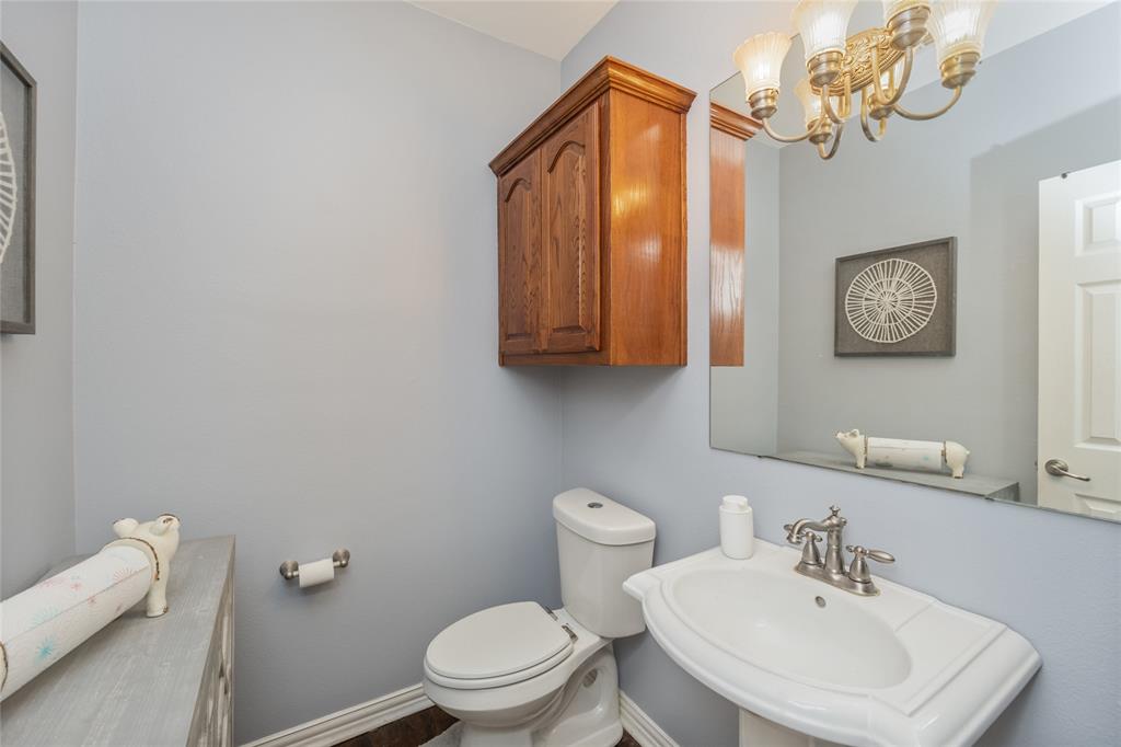 135 Kirkpatrick Road Ennis, TX 75119 - Photo 15 of 40 a bathroom with a toilet a sink and mirror