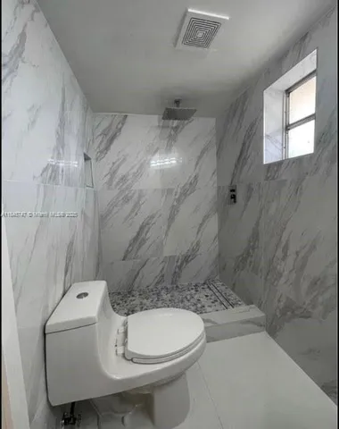 a bathroom with a toilet sink and shower