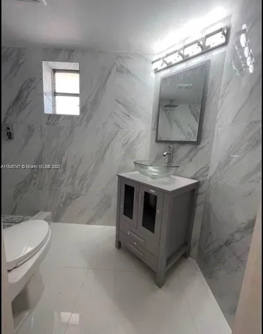 a bathroom with a sink a toilet and mirror