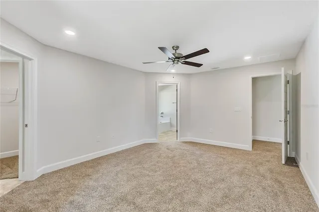 an empty room with a ceiling fan and a window